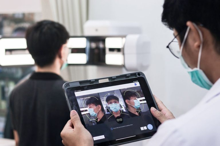 นักทัศนมาตรใช้แท็บเล็ตวัดและถ่ายภาพใบหน้าลูกค้าเพื่อตัดเลนส์ Zeiss progressive และเลนส์กรองแสงอย่างแม่นยำ